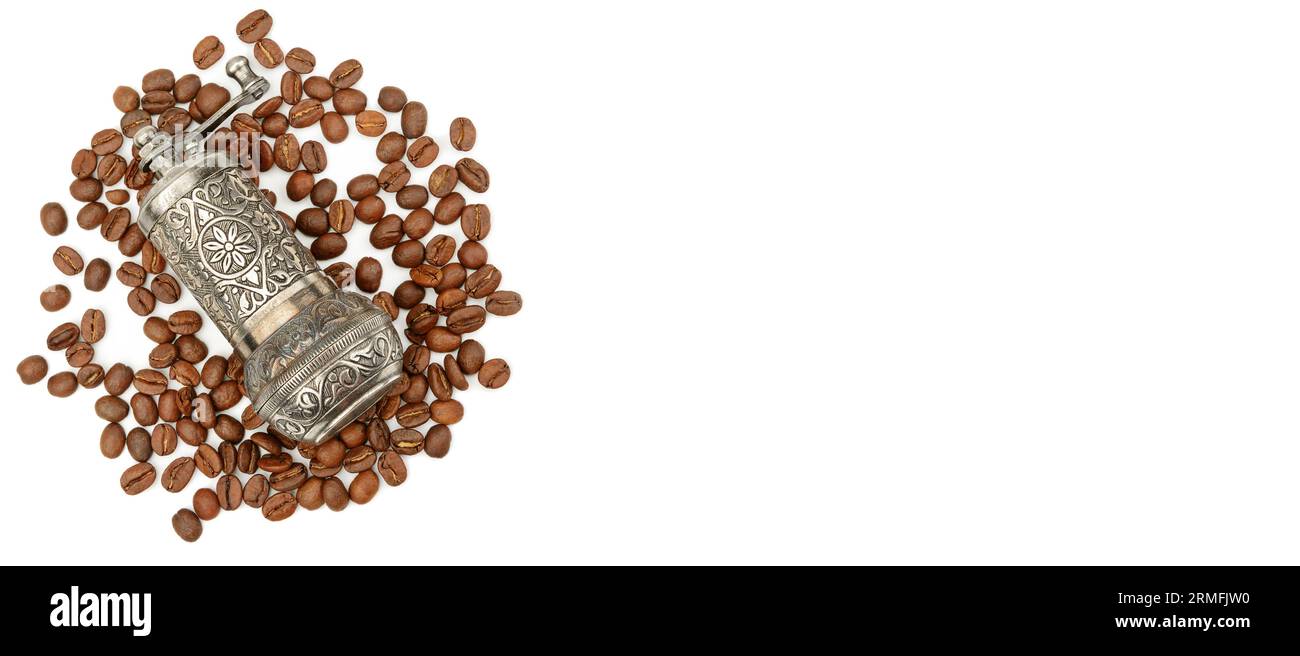 Manuelle Kaffeemühle und geröstete Kaffeebohnen isoliert auf weißem Hintergrund. Draufsicht. Freier Speicherplatz für Text. Breites Foto. Stockfoto