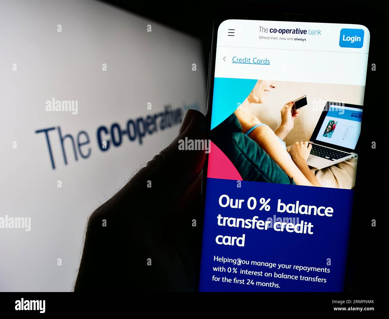 Person mit Mobiltelefon und Website des britischen Unternehmens The Co-operative Bank plc auf dem Bildschirm mit Logo. Konzentrieren Sie sich auf die Mitte der Telefonanzeige. Stockfoto