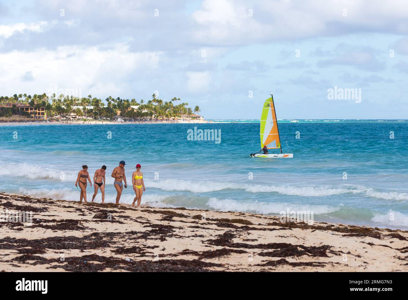 Bavaro, Dominikanische Republik - 10. Februar 2022: Karibische Landschaft. Touristen laufen den Bavaro Strand entlang Stockfoto