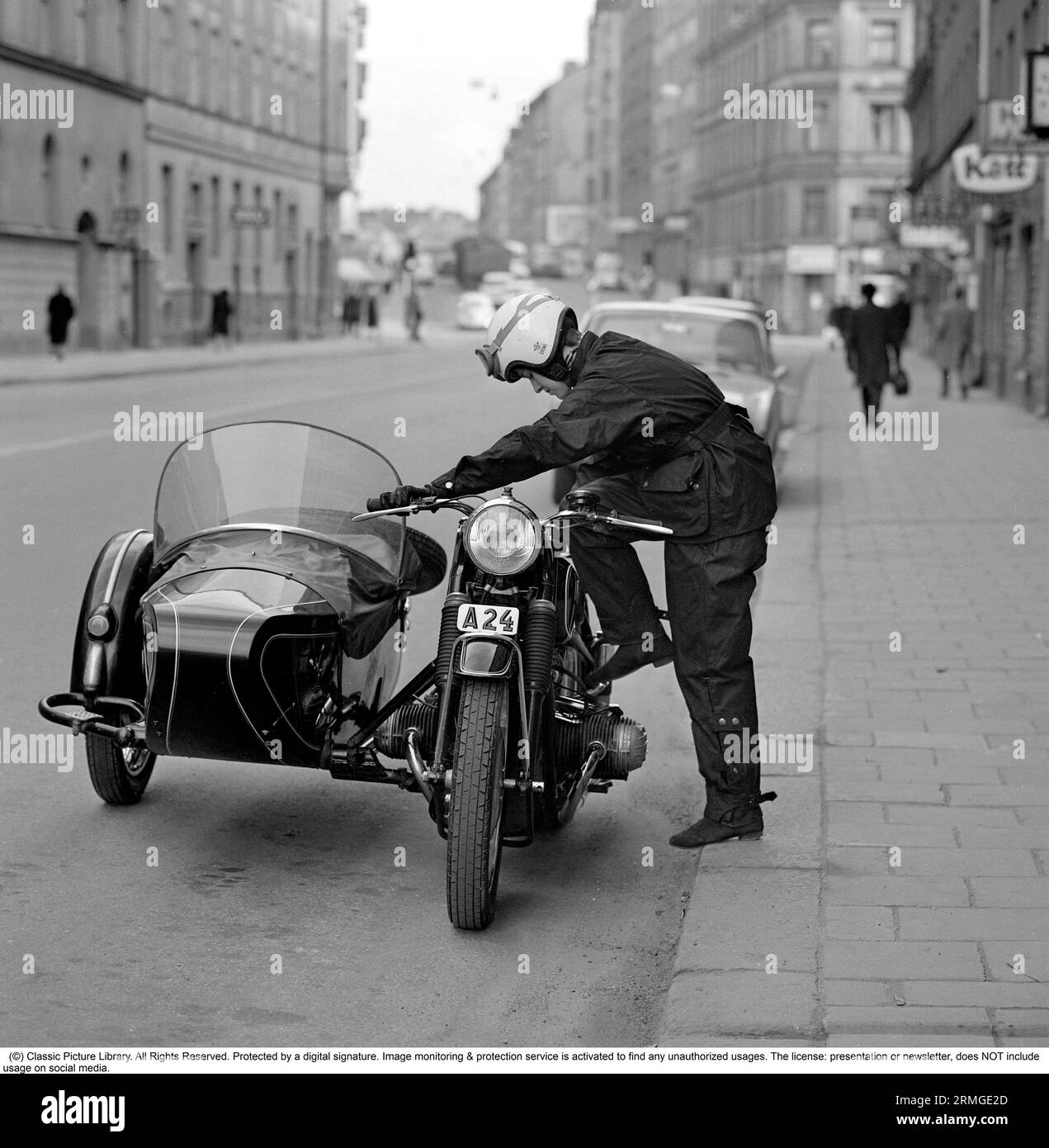 In den 1960er Jahren Eine Frau, die im typischen Motorradfahreroutfit und Helm an ihrem Motorrad mit Beiwagen für Beifahrer gesehen wurde. Schweden 1967 Stockfoto