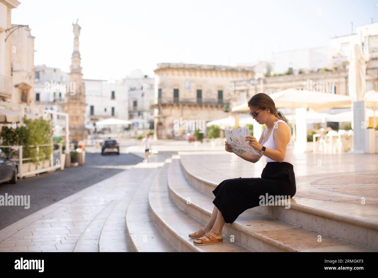 Weibliche Touristen mit einem Stadtplan von der Statue des Heiligen Oronzo in Ostuni, Italien Stockfoto