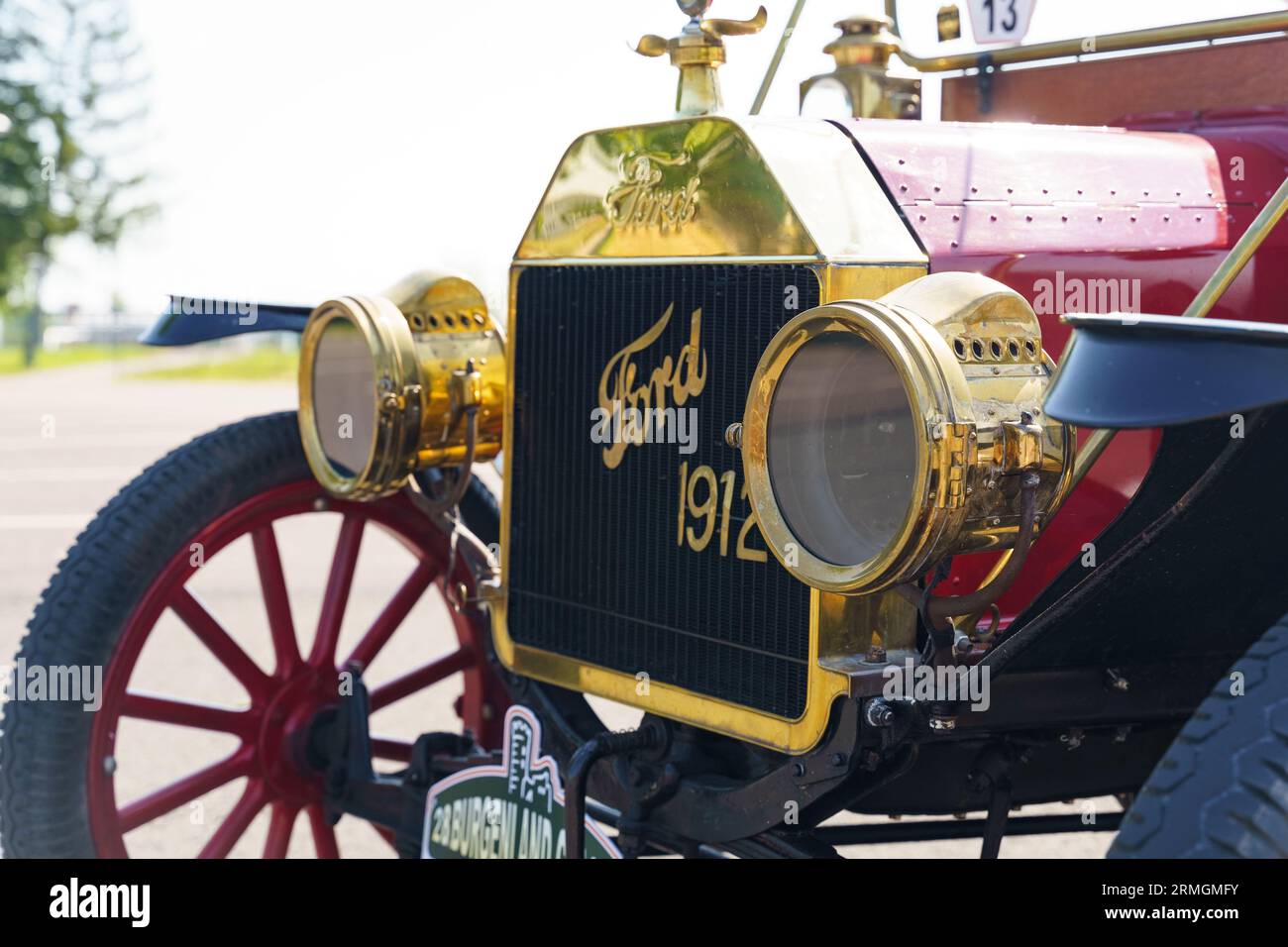 Waltershausen, Deutschland - 10. Juni 2023: Roter 1912 Ford T. Vorderansicht der Motorhaube, vergoldeter Kühlergrill und Scheinwerfer Stockfoto