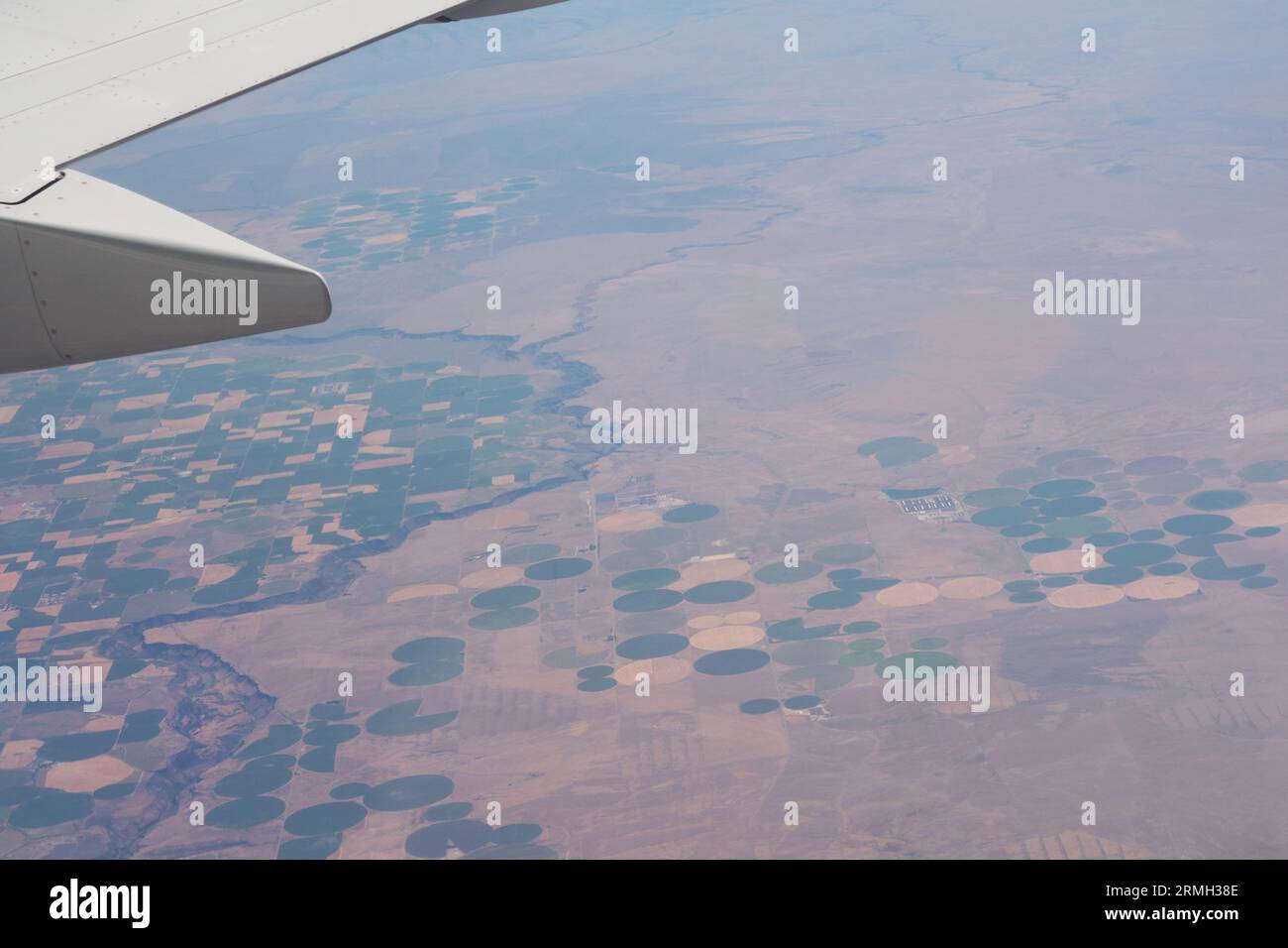 Blick vom Flugzeug aus auf Farmland darunter, einschließlich Bewässerung in der Mitte der Pivot im westlichen Teil der Vereinigten Staaten. Stockfoto