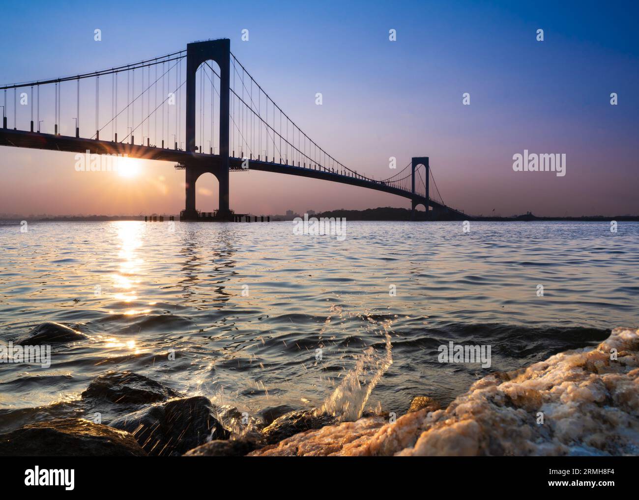 Blick auf die Whitestone Bridge in Queens, New York City bei Sonnenuntergang mit Blick auf das Wasser des Long Island Sound. Stockfoto