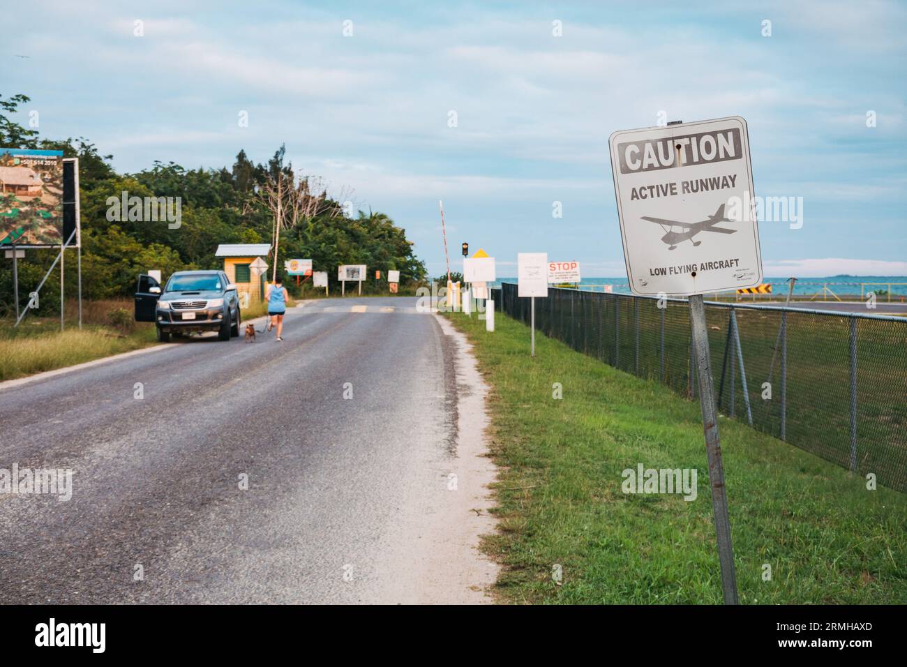 Beschilderung warnt Kraftfahrzeuge vor tief fliegenden Flugzeugen am Flughafen Placencia, Belize Stockfoto