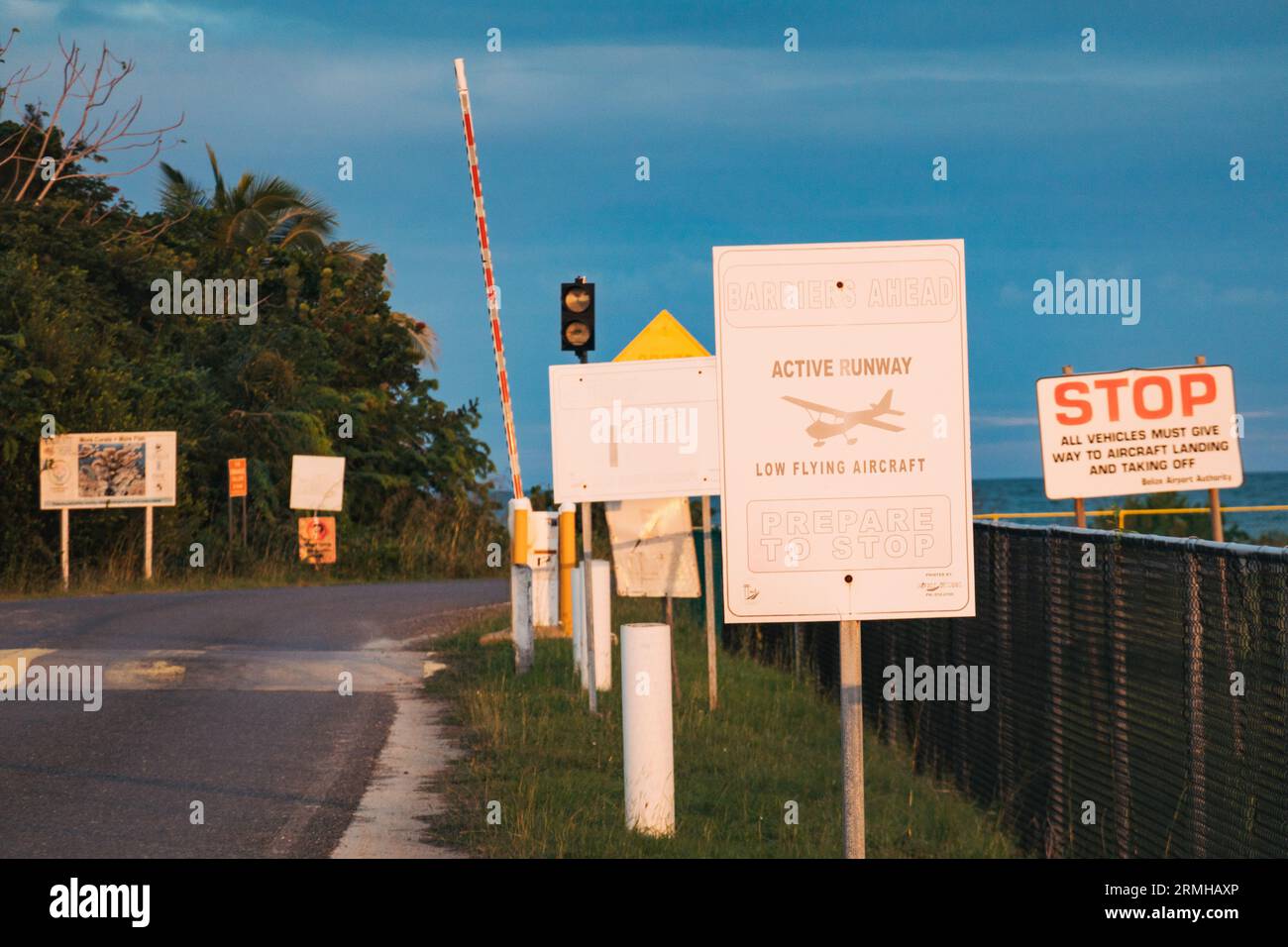 Beschilderung warnt Kraftfahrzeuge vor tief fliegenden Flugzeugen am Flughafen Placencia, Belize Stockfoto