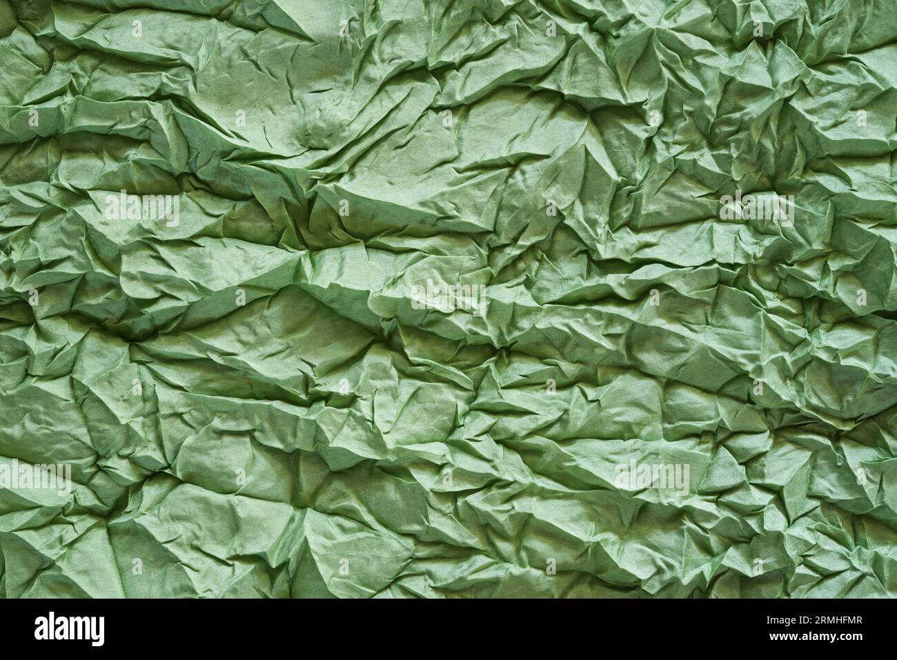 Zerknittertes Bild der Hintergrundtextur des grünen Seidentuchs aus Meeresschaum Stockfoto