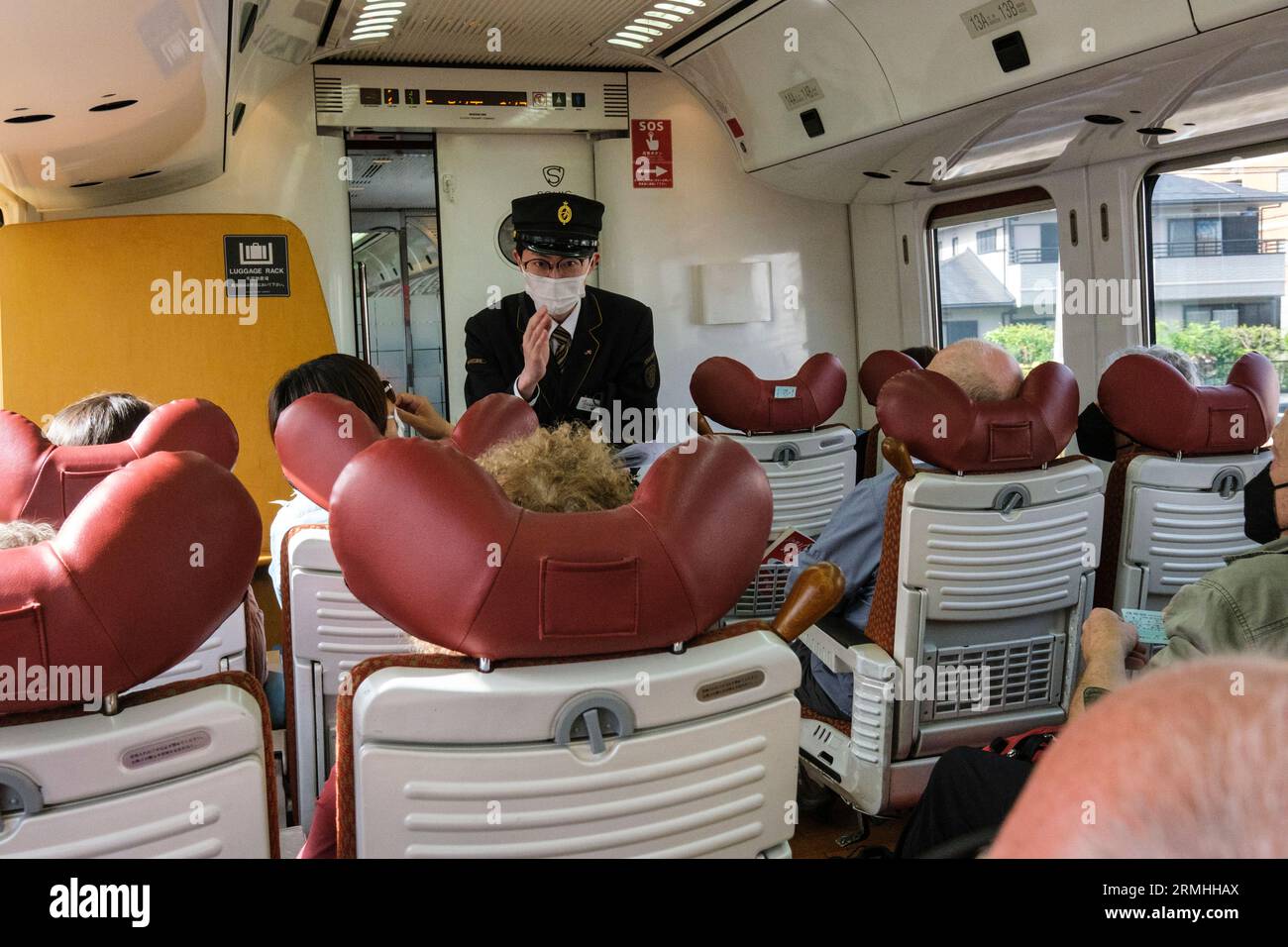 Japan, Fukuoka, Hakata. Der Leiter dankt dem Passagier für die Vorlage des Tickets. Innenraum des Personenwagens der Kyushu Railway. Stockfoto