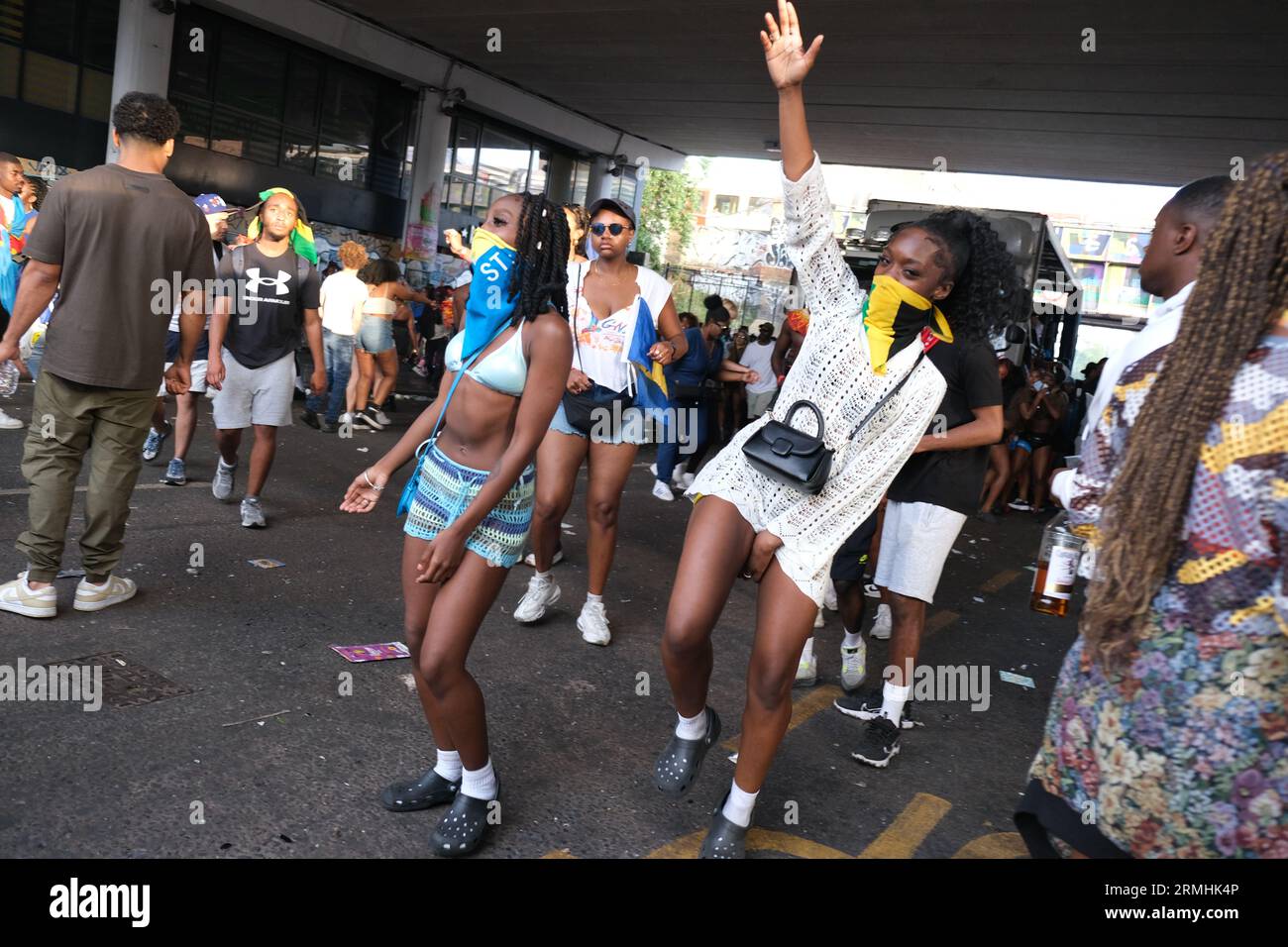 Mädchen, die Jamaika und St. Lucia Gesichtsmasken tragen, tanzen vor einem Musik-Truck während der Karnevalsfeier der Karibik. 28/08/20 Stockfoto