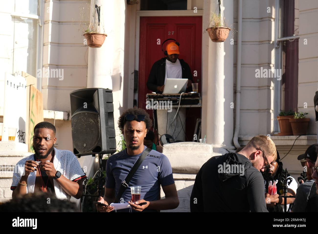 Der Mann spielt Musik von seinem Computer vor der Tür eines Hauses während der jährlichen Karnevalsfeier der Karibik. 28/08/2023 Stockfoto