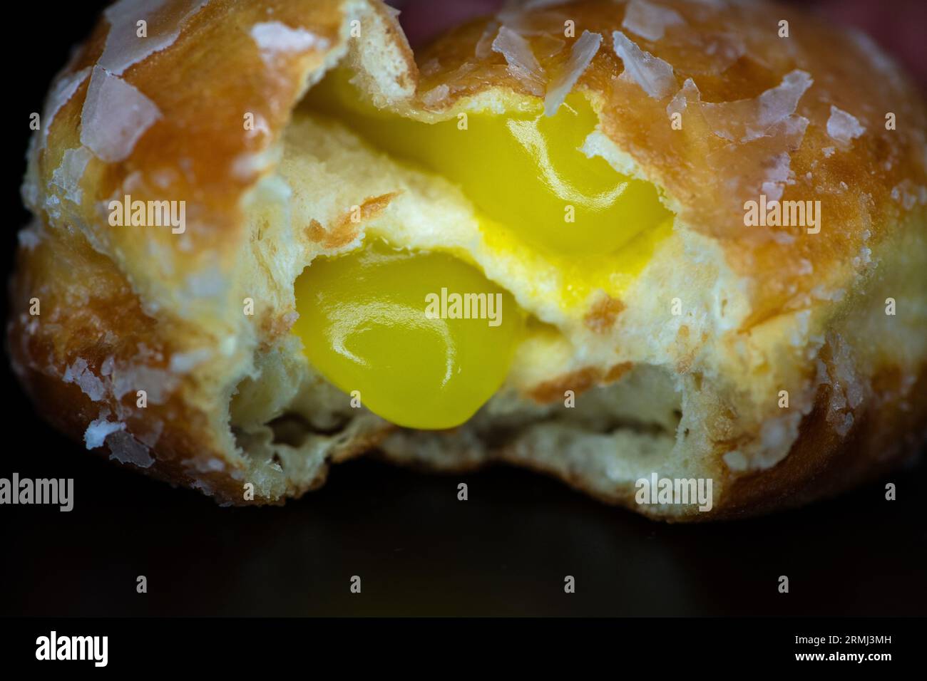 Mit Zitrone gefüllter Gelee-Donut mit einem Happen Stockfoto