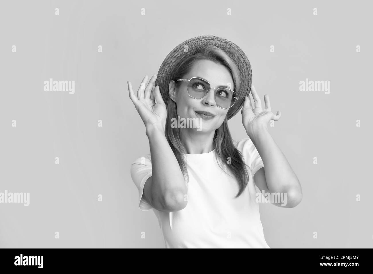 Porträt einer lustigen Frau in stilvoller Sonnenbrille und Strohhut auf gelbem Hintergrund. Stockfoto