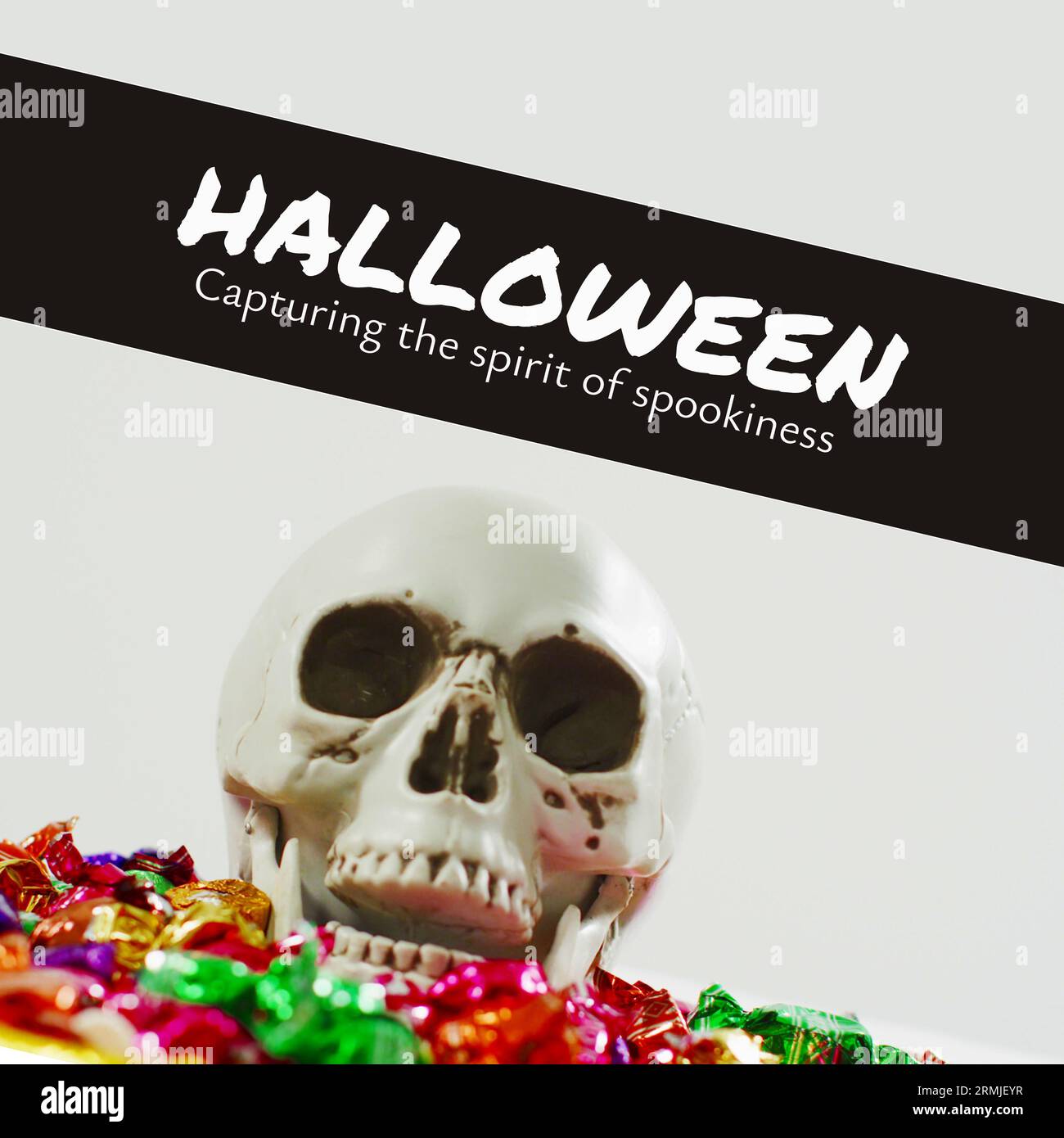 Komposition aus menschlichem Schädel, Süßigkeiten und halloween, die den Geist der Spoofness, Kopierraum einfangen Stockfoto