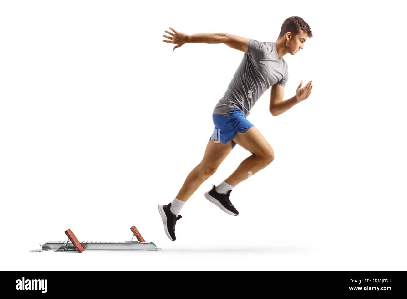 Profilaufnahme in voller Länge eines FIT Guys beim Laufen mit Startblöcken, isoliert auf weißem Hintergrund Stockfoto