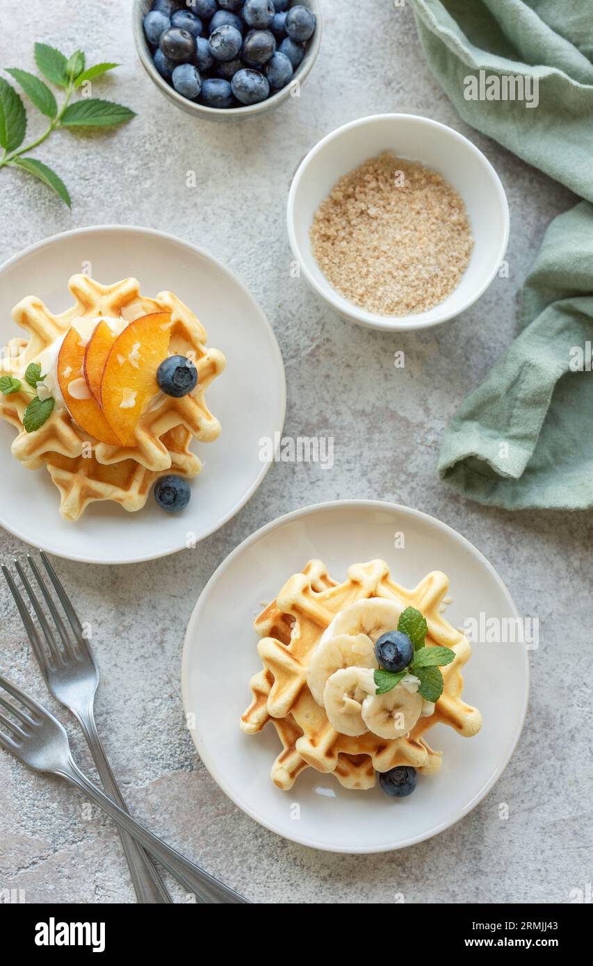 Belgische Waffeln mit Obst, Bananen und Honig. Hausgemachtes Backen. Konzept des gesunden Frühstücks. Stockfoto