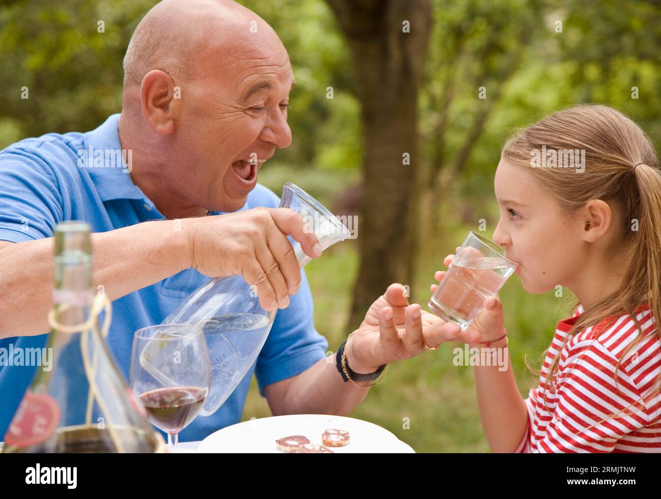 Großvater und Enkeltochter trinken Wasser Stockfoto