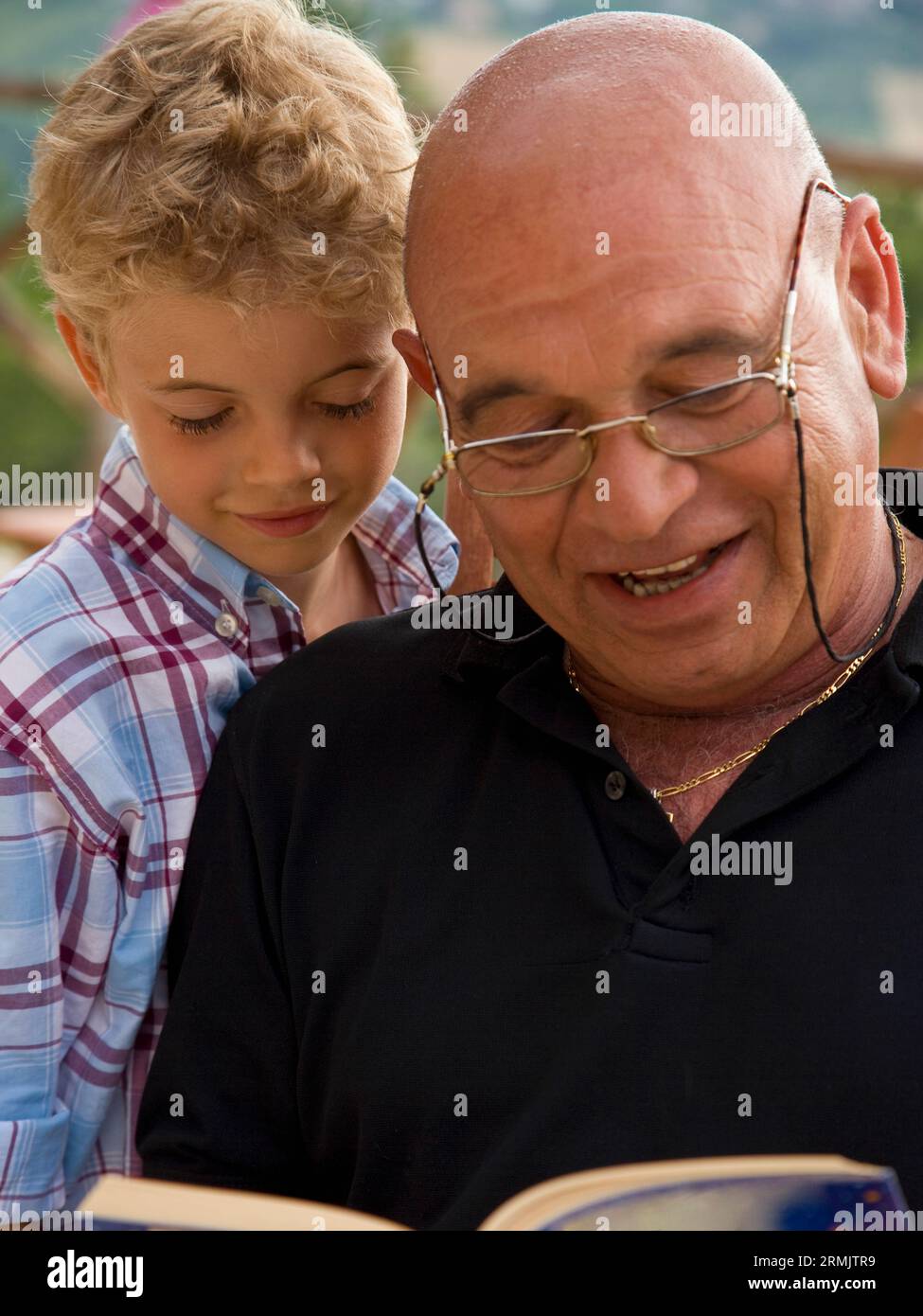 Großvater liest Buch an Enkel Stockfoto