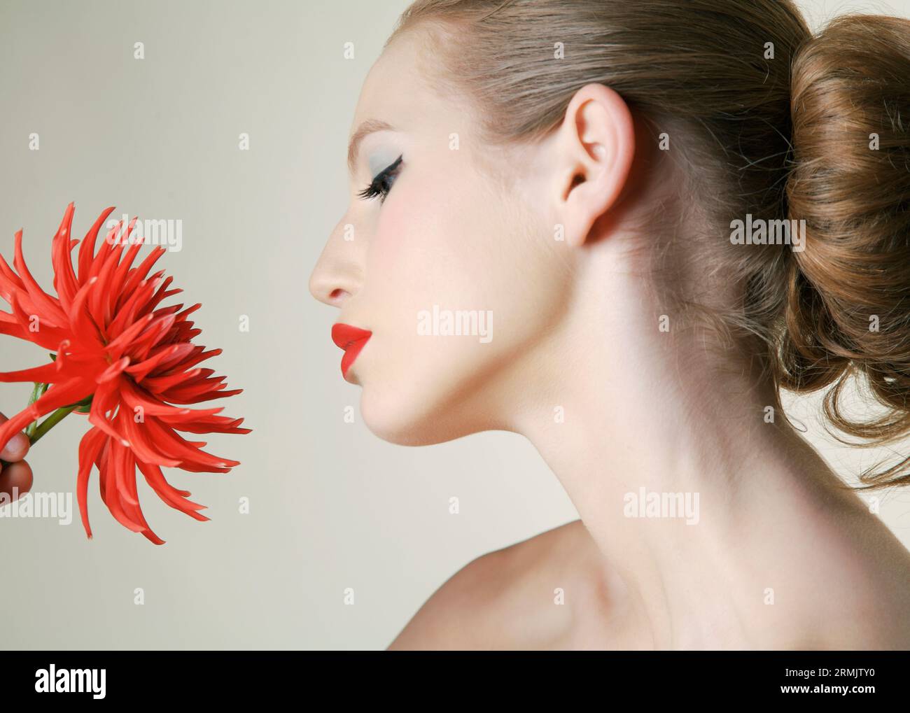 Junge Frau mit roter Dahlie Stockfoto