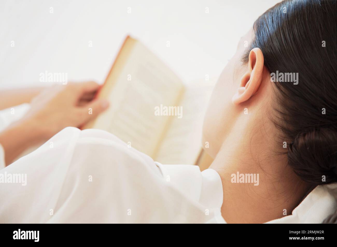 Rückansicht einer Frau, die Buch liest Stockfoto