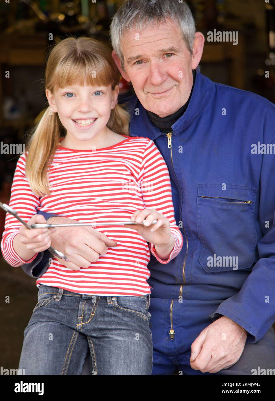 Porträt von Großvater und Enkelin hält lächelnd Schraubenschlüssel Stockfoto