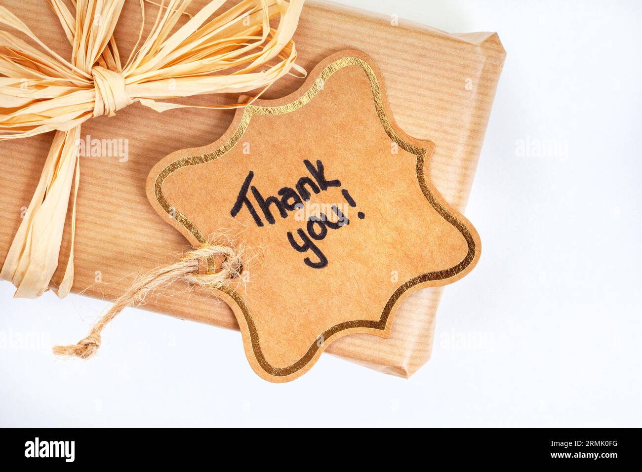 Rustikales Geschenk mit Dankeschön, handgeschrieben auf Karton Stockfoto