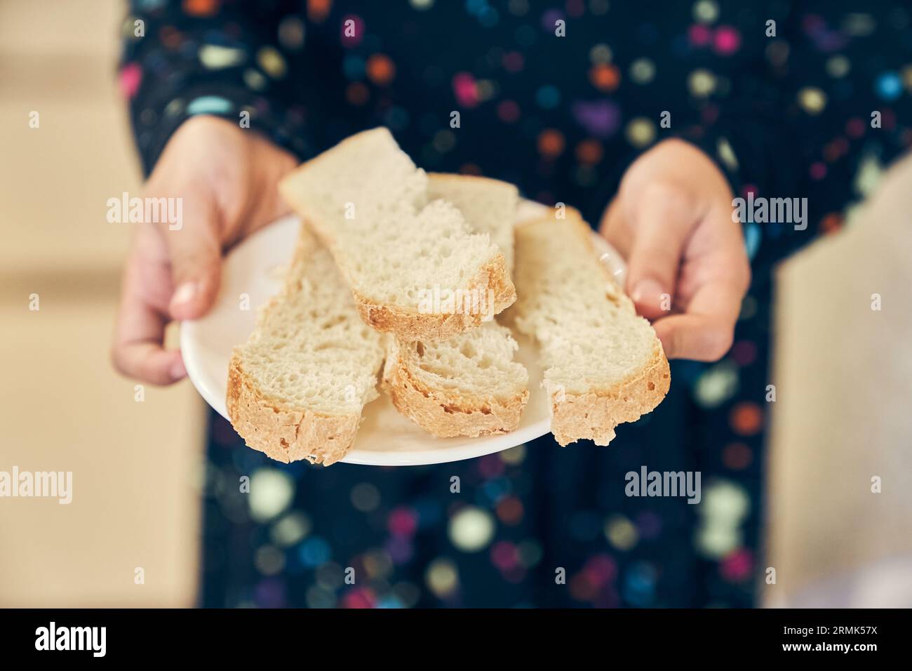 Vollkornbrot auf einem Teller, das Kind hält einen Teller. Frisches Brot aus nächster Nähe. Das Konzept der gesunden Ernährung und der traditionellen Bäckerei. Hochwertige Fotos Stockfoto
