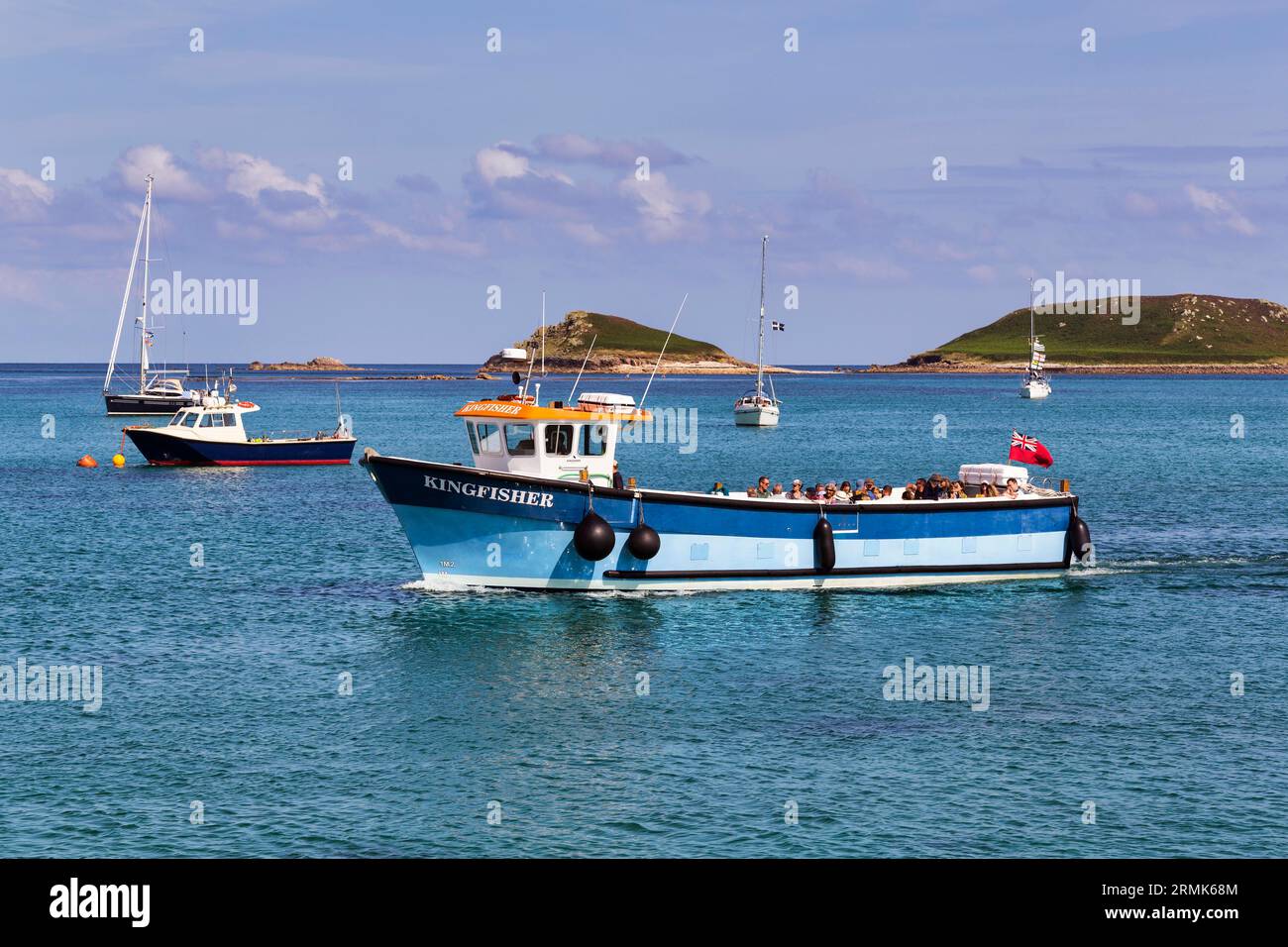 Touristen auf Ausflugsboot, Frühlingswolken, höhere Stadt, St. Martin's, Scilly-Inseln, Cornwall, England, Großbritannien Stockfoto