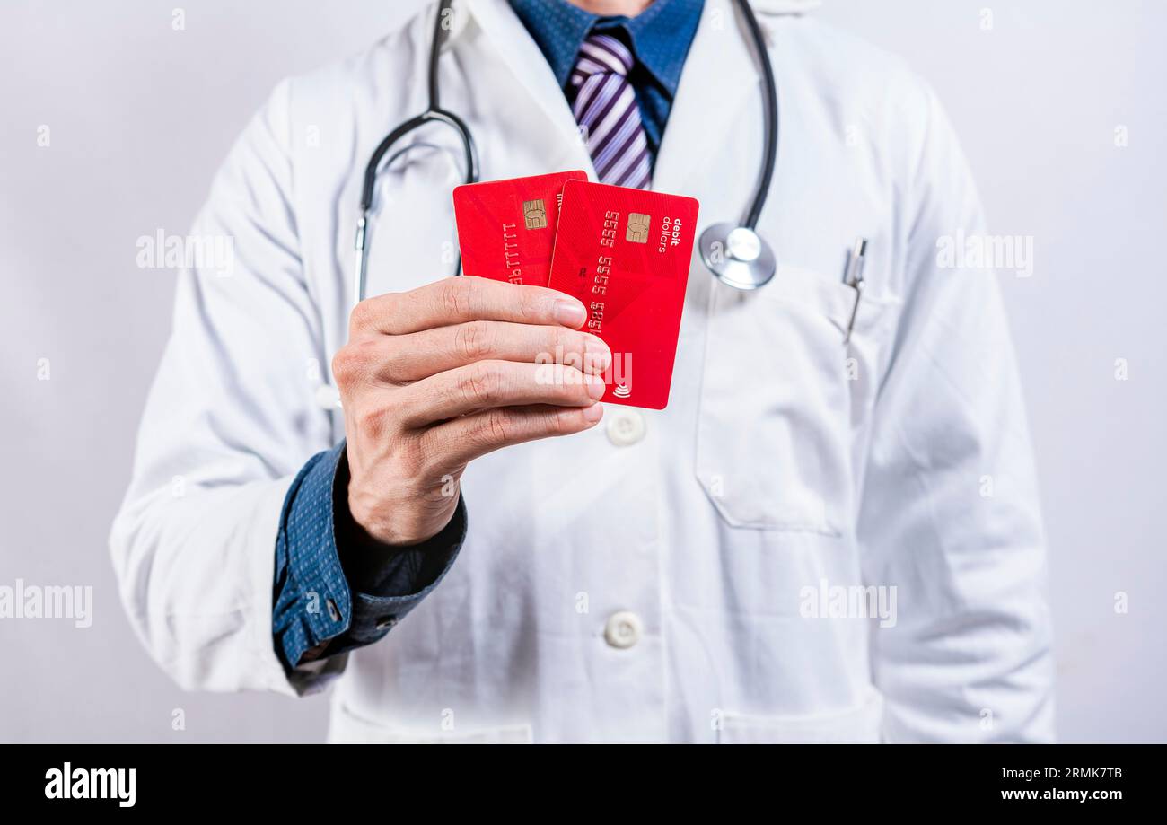 Arzthänder mit Kreditkarten. Arzt, der zwei Kreditkarten isoliert hält. Konzept der ärztlichen Kartenzahlung Stockfoto