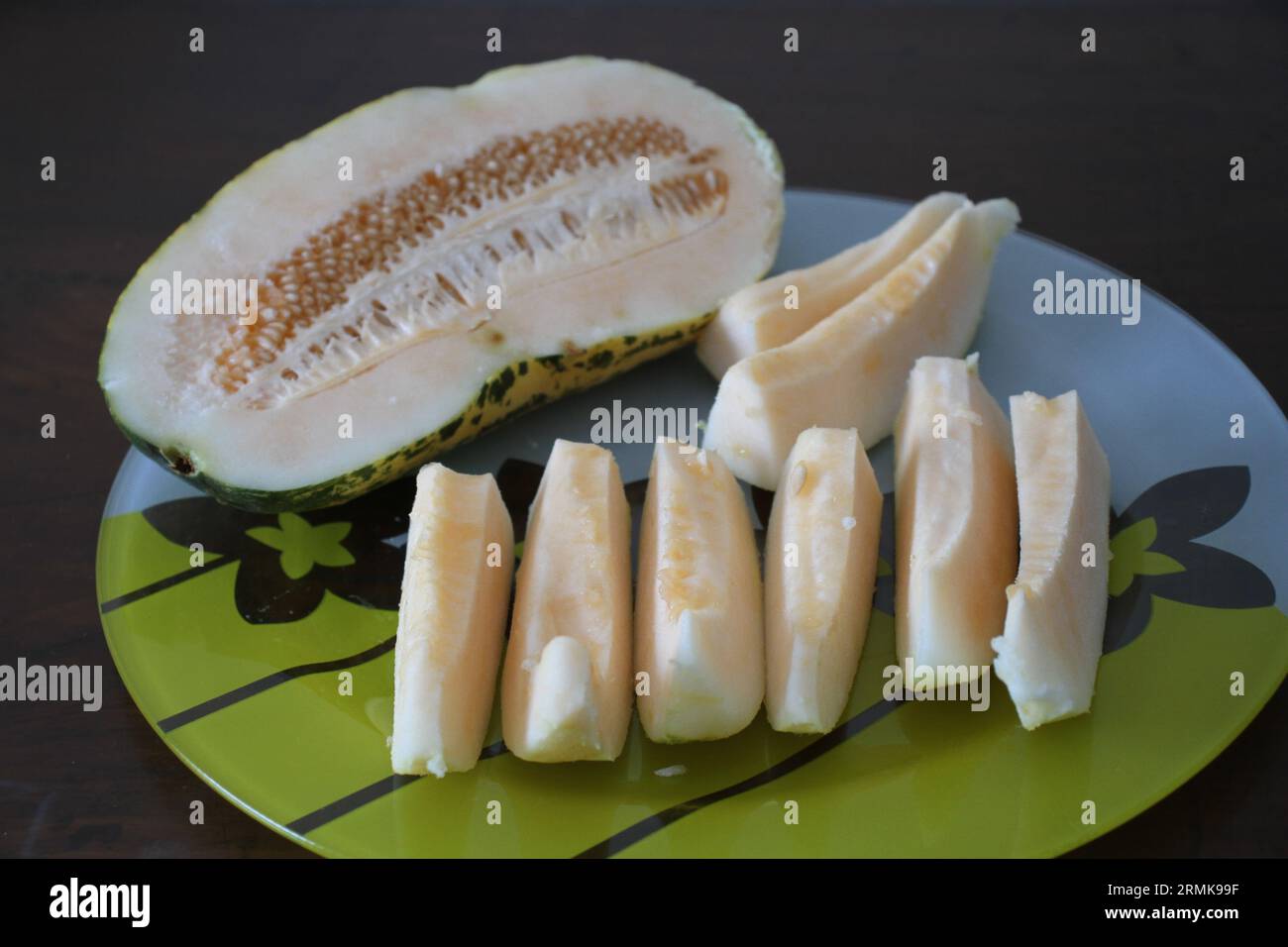 Eine Melone und Scheiben auf einem Teller. Stockfoto