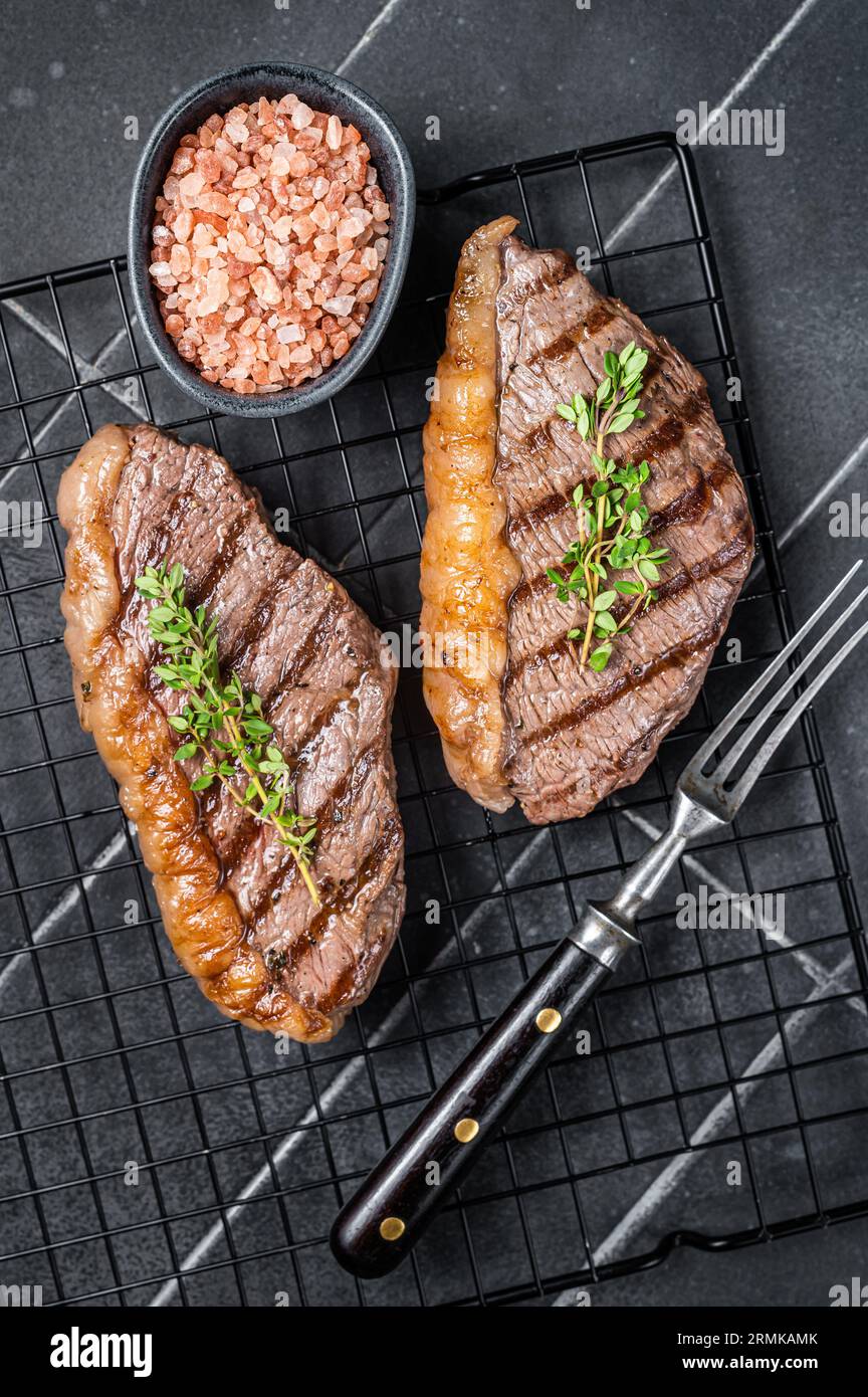 Gegrilltes Filet oder Tasse Rumpsteak auf einem Regal. Schwarzer Hintergrund. Draufsicht. Stockfoto