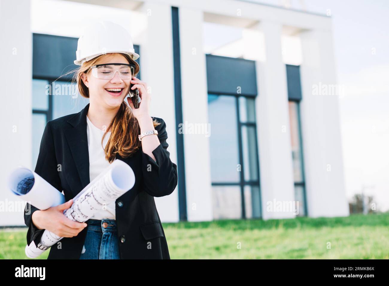 Fröhliche Architektin, die telefoniert Stockfoto