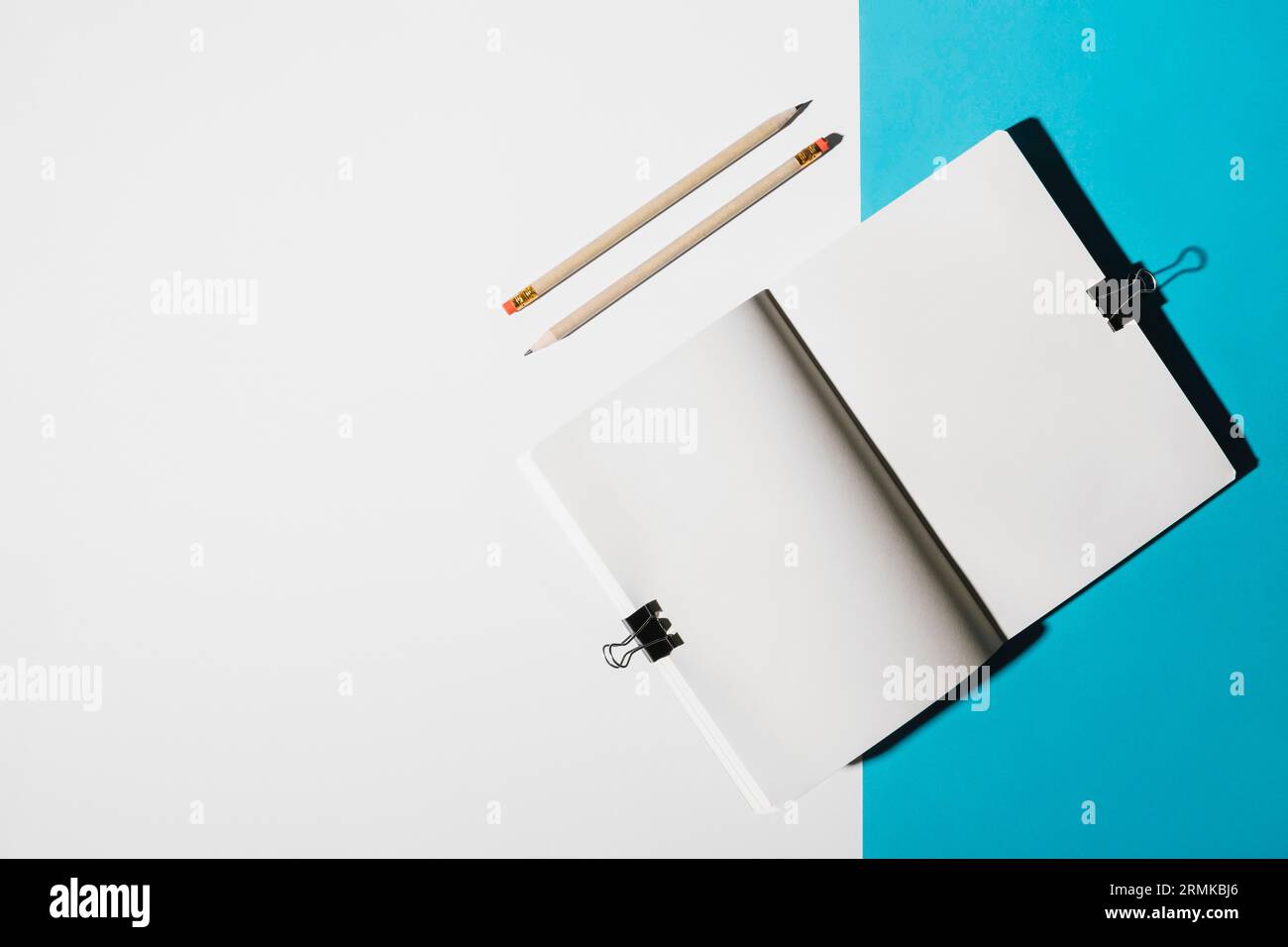 Erhöhte Ansicht zwei Stifte öffnen das Notebook mit einem Bulldog-Clip Stockfoto