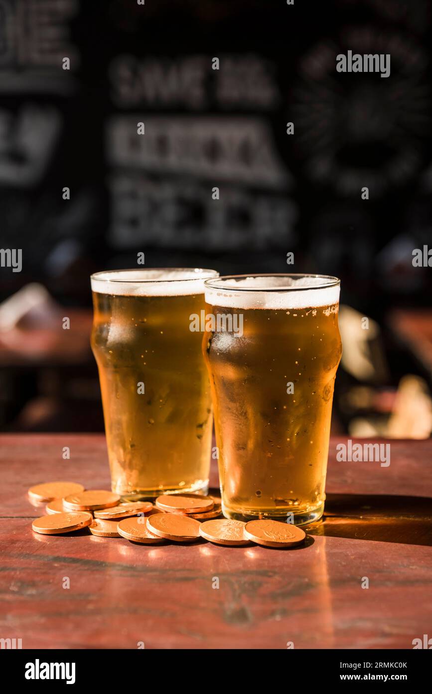 Gläser trinken in der Nähe von Haufen-Münzen-Tisch Stockfoto