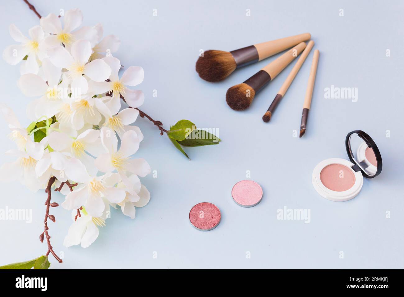 Overhead-Ansicht Kirschblüten Make-up Pinsel Rouge farbigen Hintergrund Stockfoto