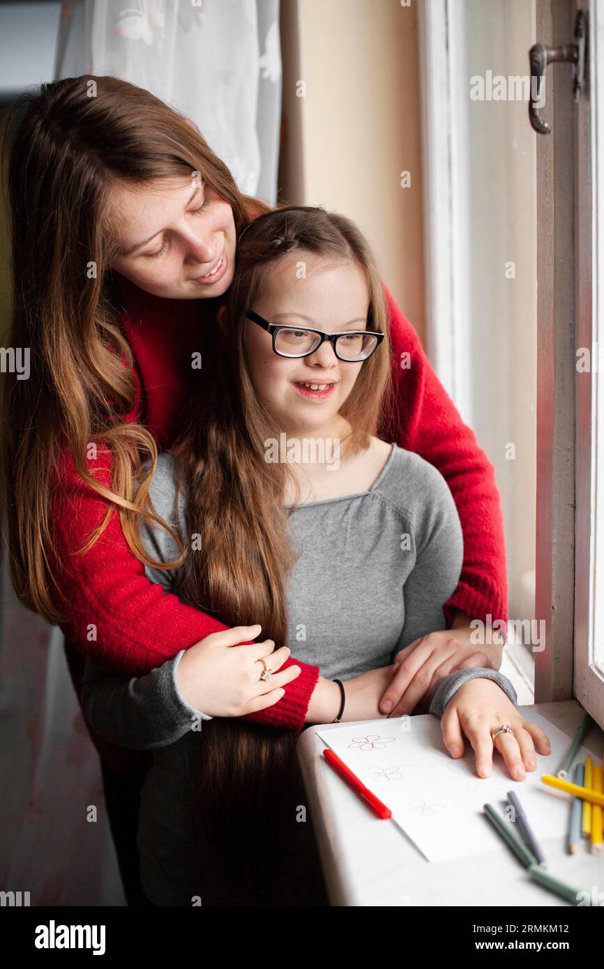 Frau mit Down-Syndrom, die am Fenster posiert Stockfoto