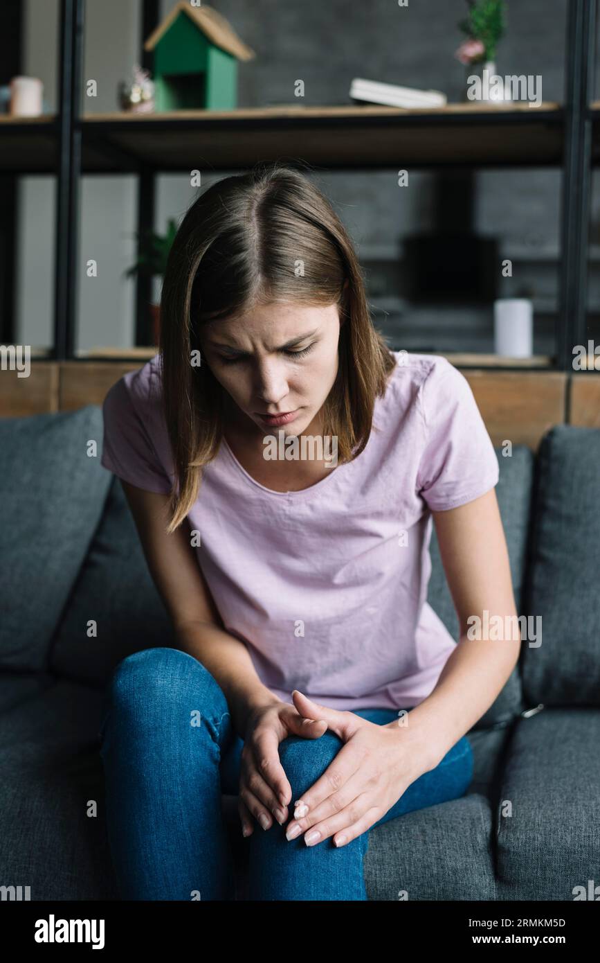 Junge Frau mit Knieschmerzen Stockfoto