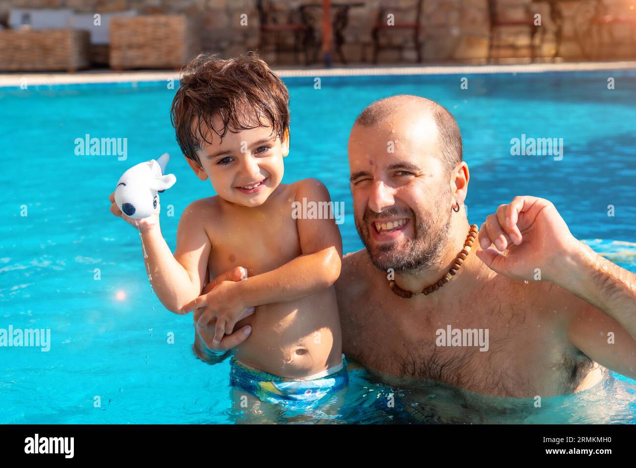 Porträt von Vater und Sohn im Swimmingpool im Sommer spielen genießen und lächeln im Urlaub Stockfoto