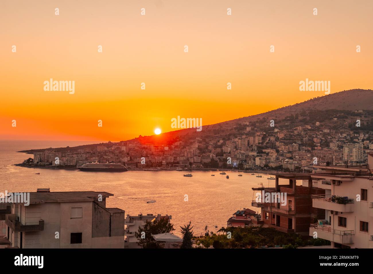 Panoramablick bei Sonnenuntergang auf den Strand und die Stadt hoch über der albanischen Riviera Stadt Sarande, Albanien Stockfoto