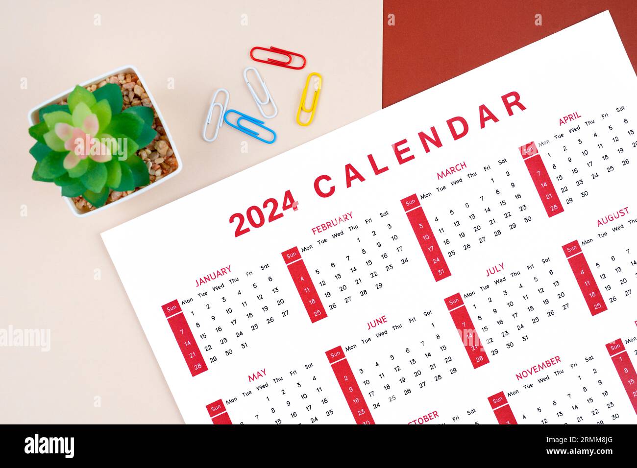 Kalender 2024 Seite mit Büroklammer und Pflanztopf auf schönem Hintergrund. Stockfoto