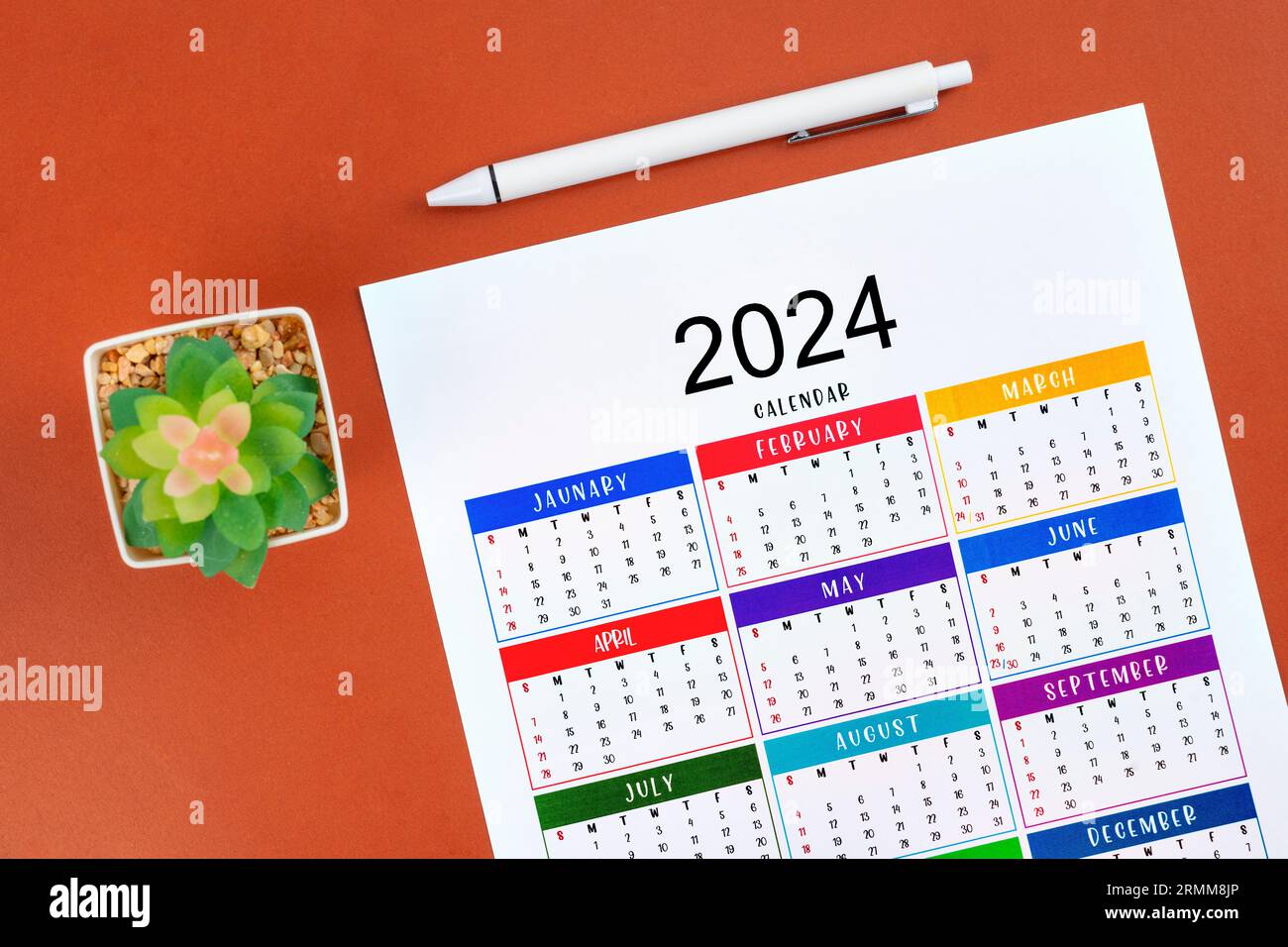 Kalender 2024 Seite und weißer Stift mit Pflanztopf auf schönem Hintergrund. Stockfoto