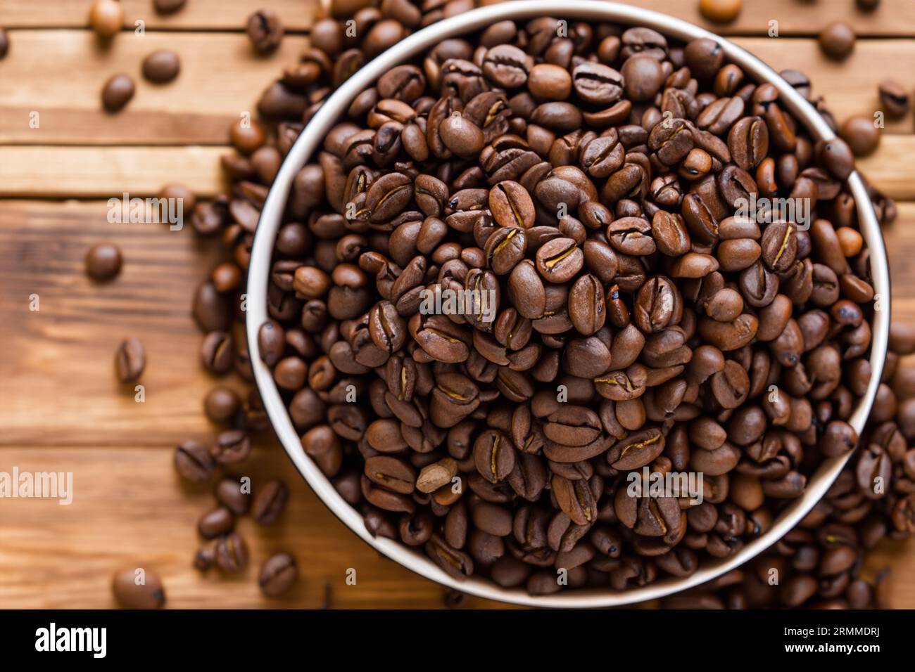 Schüssel voll mit Bio-Kaffeebohnen auf altem Holztisch Stockfoto