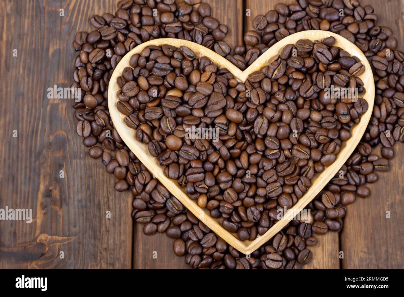 Schüssel voll mit Bio-Kaffeebohnen auf altem Holztisch Stockfoto