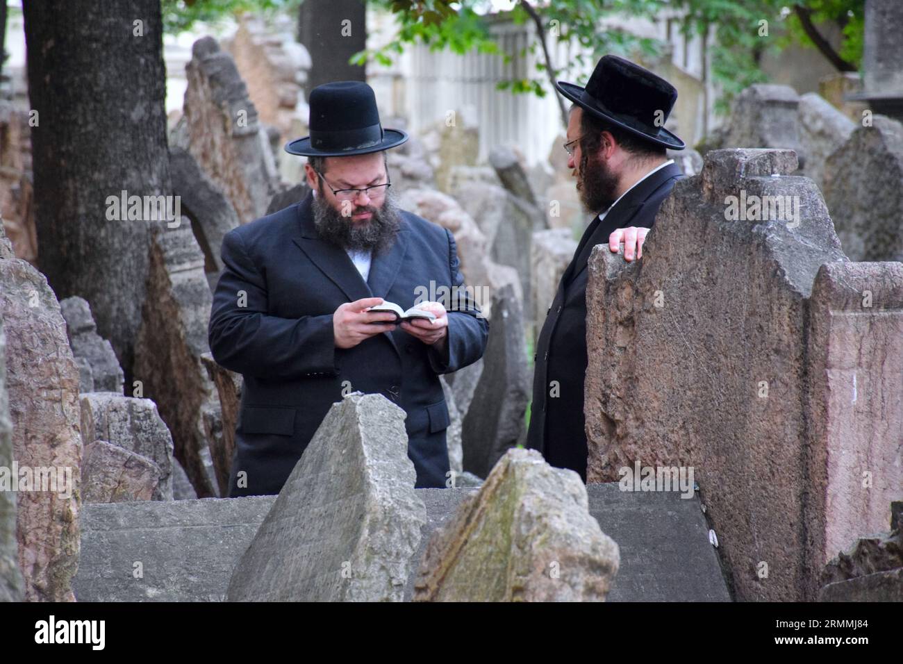Der Alte jüdische Friedhof in Josefov, dem jüdischen Viertel, in Prag - Tschechische Republik. Einige traditionell gekleidete juden beten. Stockfoto