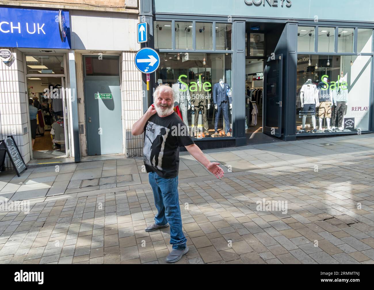 Gentleman posiert vor Bekleidungsgeschäften, High Street, Lincoln City, Lincolnshire, England, UK Stockfoto