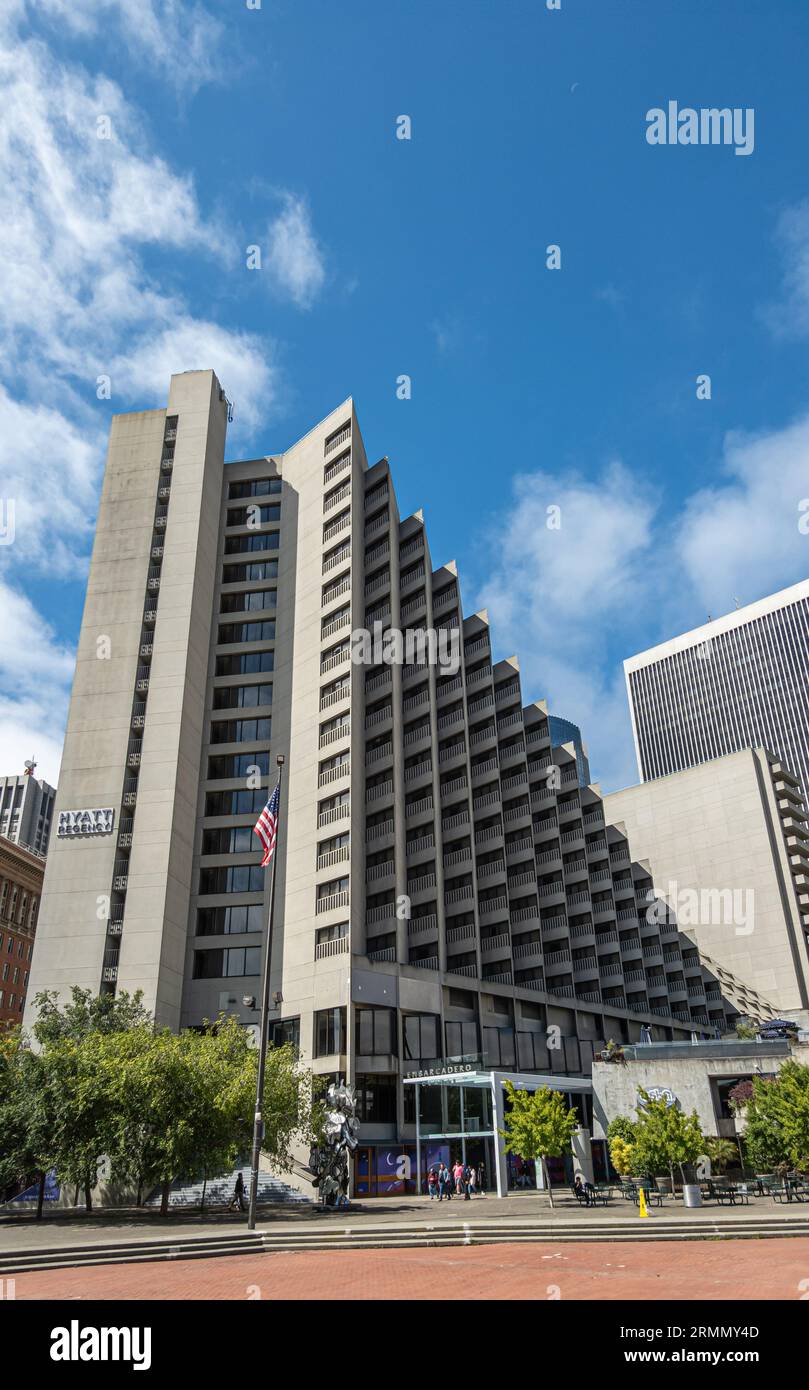 San Francisco, CA, USA - 12. Juli 2023: Nahaufnahme, Hyatt Regency Hotel am Embarcadero Plaza unter blauem Wolkenbild. Finanzdistrikt hinten. Grün fol Stockfoto