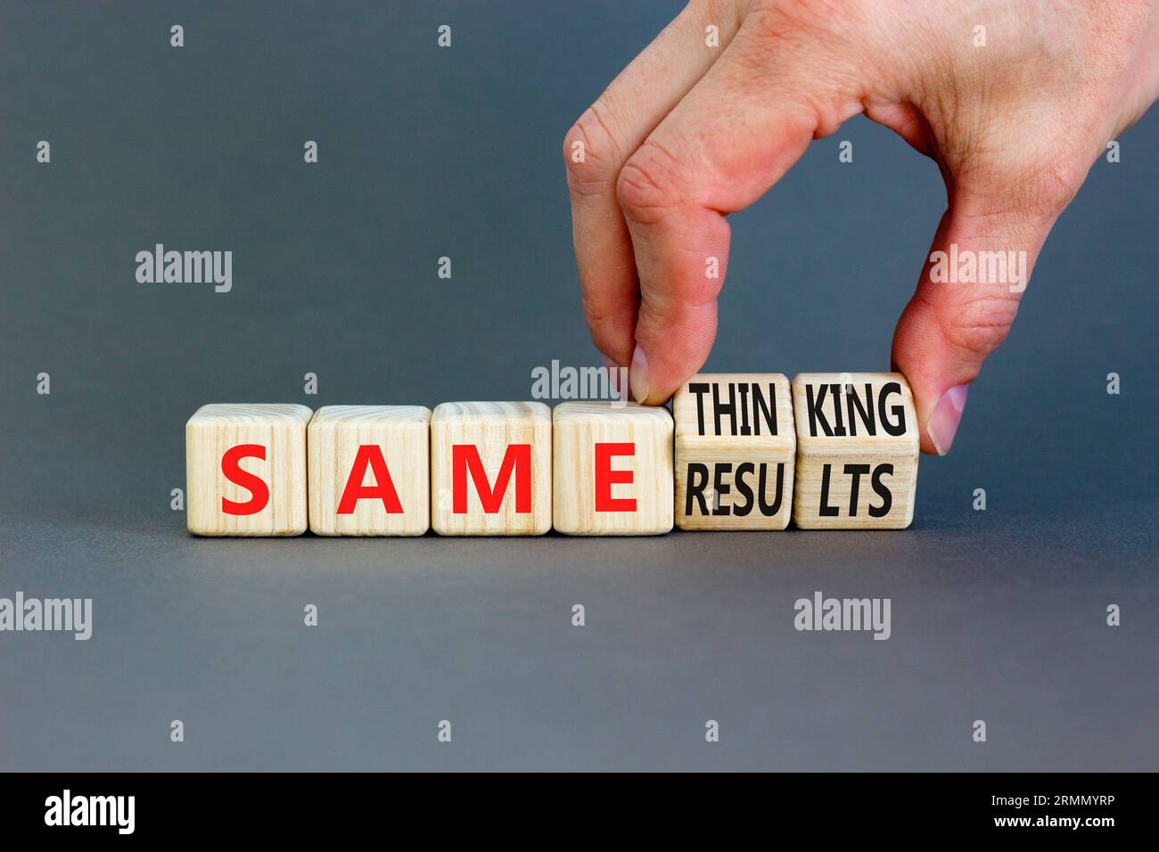 Dasselbe Symbol für Denken und Ergebnis. Konzept Worte dasselbe Denken gleiche Ergebnisse auf Holzwürfeln. Schöner grauer Hintergrund. Geschäftsmann Hand. Geschäftlich gleich Stockfoto