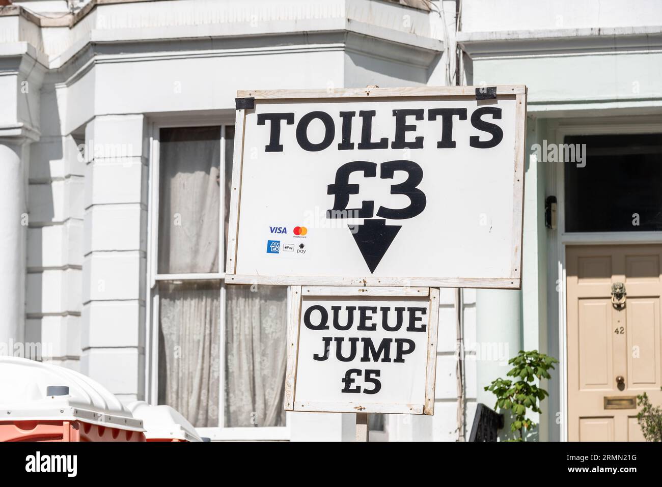 Gäste, die Toiletten in ihrer Anlage bei der Notting Hill Carnival Grand Parade 2023, London, Großbritannien, anbieten. Option Warteschlangensprung gegen zusätzliche Gebühr Stockfoto
