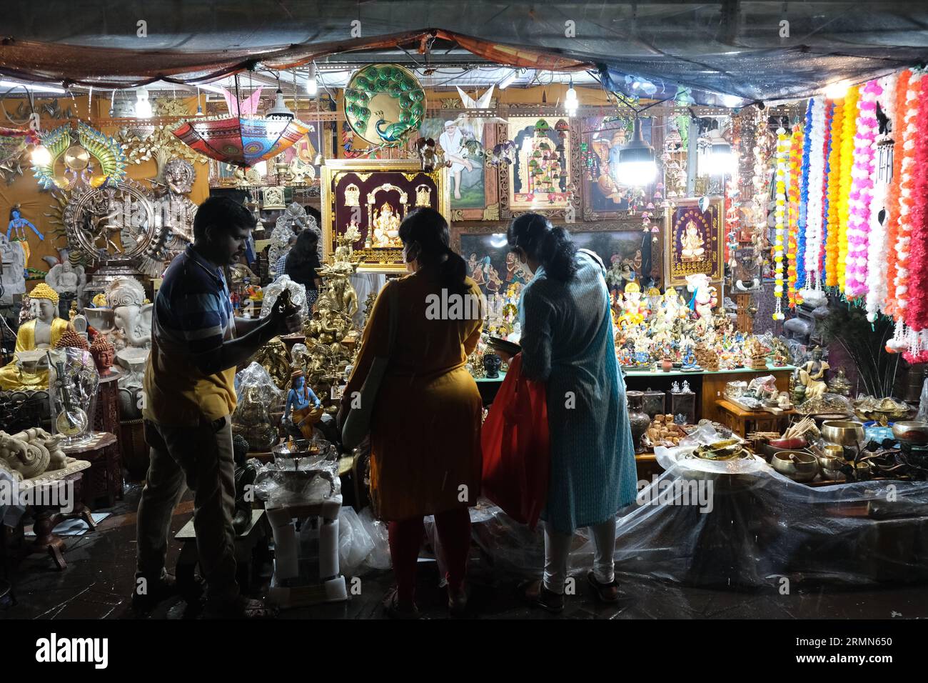 Indische Frauen feilschen mit einem Standhalter auf einem Nachtmarkt in Singapurs belebtem Little India Viertel. 22/10/2022 Stockfoto