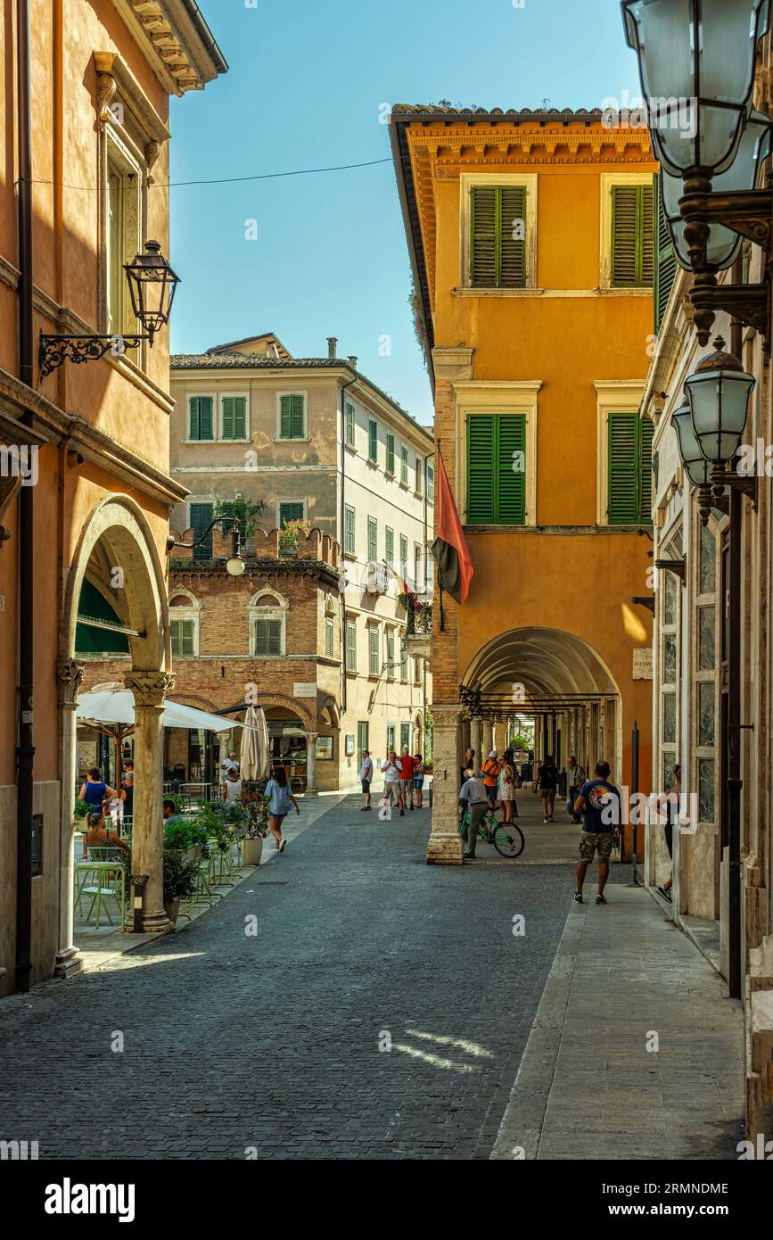 Die Arkaden der edlen Paläste mit Blick auf die Piazza del Popolo. Touristen spazieren durch das historische Zentrum von Ascoli. Ascoli Piceno, Marken, Italien, Stockfoto