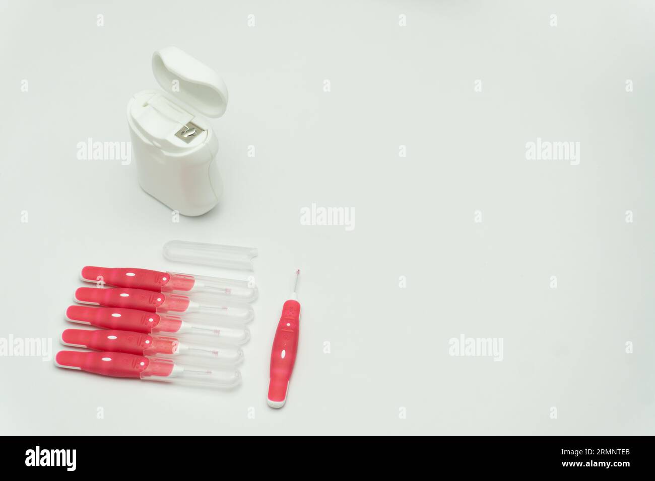 Interdentalbürstenstifte und Zahnseide auf weißem Hintergrund, Kopierraum Stockfoto